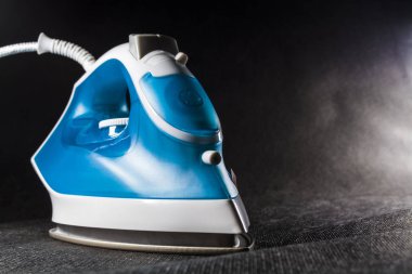 Elektrik mavi demir beyaz renk ile. Modern küçük ev aletleri ev için. Ütü. Siyah arka plan.