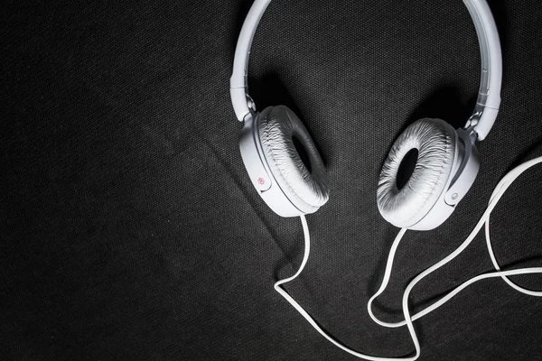 Weiße große Kopfhörer zum Musikhören. für Telefon. Haut. schwarzer Hintergrund. tragbar. Gadgets. schön und modisch. — Stockfoto