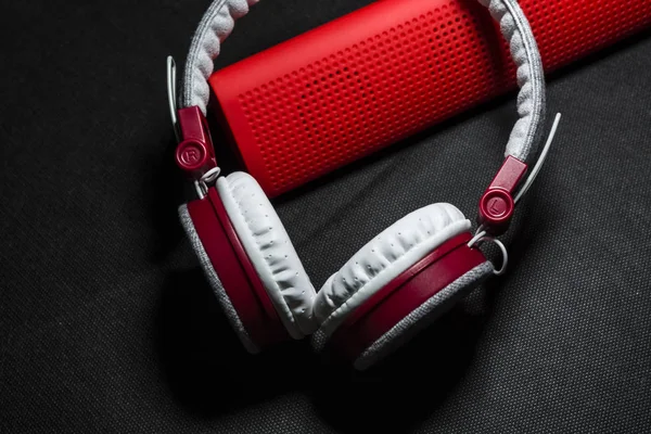 Velký přenosný a pestrobarevným sluchátka a červený reproduktor pro poslech hudby. Bílé a červené barvy. Na černém pozadí — Stock fotografie