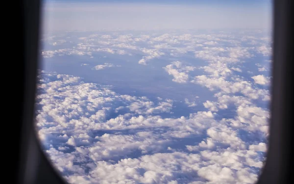 View from a window of the passenger plane on the sky and the earth from height. Beautiful view from air. Clouds and blue sky. — Stock Photo, Image