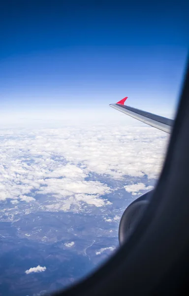 从客机的窗户可以从天空和地球的高度观看。从空中看美丽的景色。云和蓝天. — 图库照片