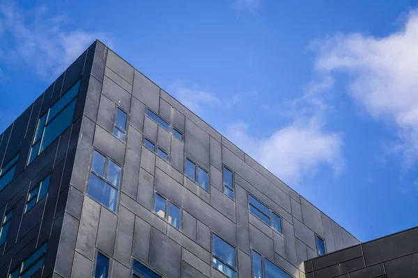 Sobre el fondo del cielo azul veraniego de un detalle de construcciones modernas negras y grises. Arquitectura inusual. Innovación — Foto de Stock