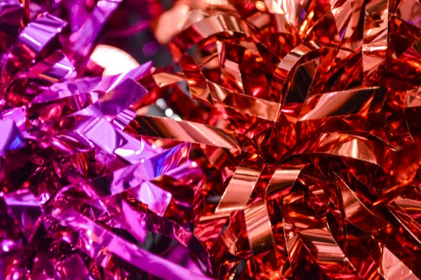 Konfetti. festlicher Schmuck, eine Dekoration aus dem Neujahrsregen. Hintergrund oder Textur. leuchtend purpurrote, rote und rosa Farben. Urlaub. — Stockfoto