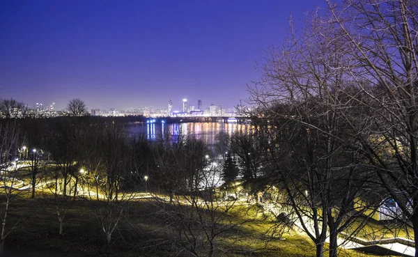 Прекрасный вид на вечерний Киев и реку. Ночные пожары в городе. Весной. Пейзаж . — стоковое фото