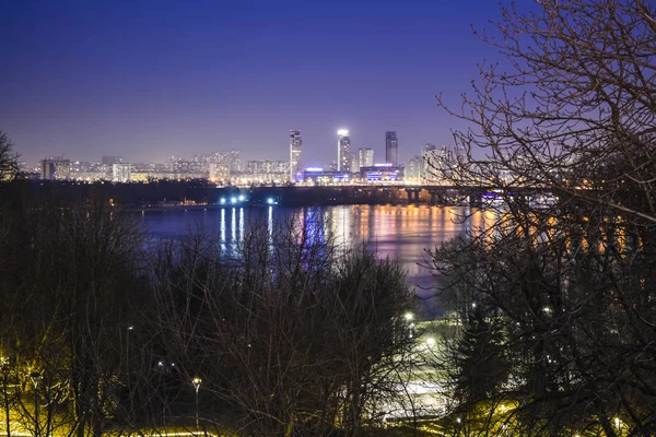 Hermosa vista de la noche Kiev y el río. Los incendios nocturnos de la ciudad. Primavera. Paisaje . — Foto de Stock