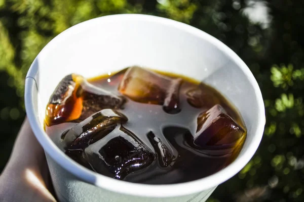Nagy jég egy erős kávé pohár kocka. Alternatív hideg sört kávét inni. A színek és a foltok a fény játék. — Stock Fotó
