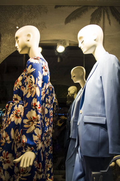Female dummies in stylish and fashionable clothes in a show-window of shop. Bags. New collection. Shopping.