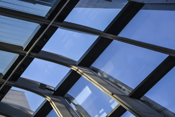 Nowoczesne budynki nietypowych form ze szkła i metalu. Geometrii linii i krzywych. Pochyła fasada. Błękitne niebo. — Zdjęcie stockowe