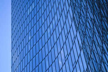 Ofis binaları modern mimarisi. Cam ve metal bir eğri dalga şeklinde bir gökdelen. Mavi gökyüzü ve evleri Windows yansımaları. İş Merkezi.
