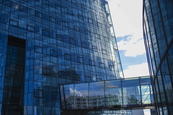 Arquitectura moderna de edificios de oficinas. Un rascacielos de cristal y metal. Reflejos en ventanas de cielo azul. Centro de negocios — Foto de Stock