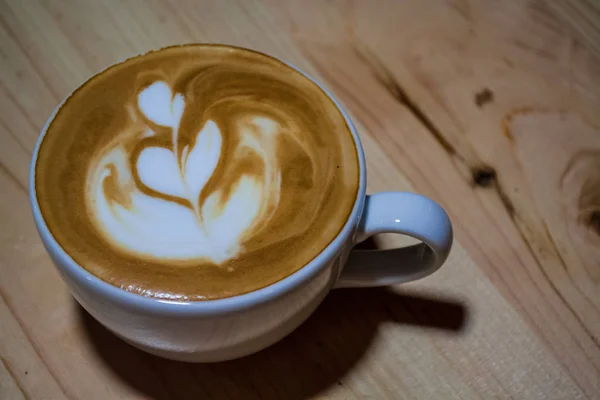 Cappuccino-Tasse mit Latte Art vorhanden. Kaffee mit Milch. Arbeit Barista. frisches Getränk mit Koffein. — Stockfoto