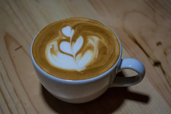 Cappuccino-Tasse mit Latte Art vorhanden. Kaffee mit Milch. Arbeit Barista. frisches Getränk mit Koffein. — Stockfoto