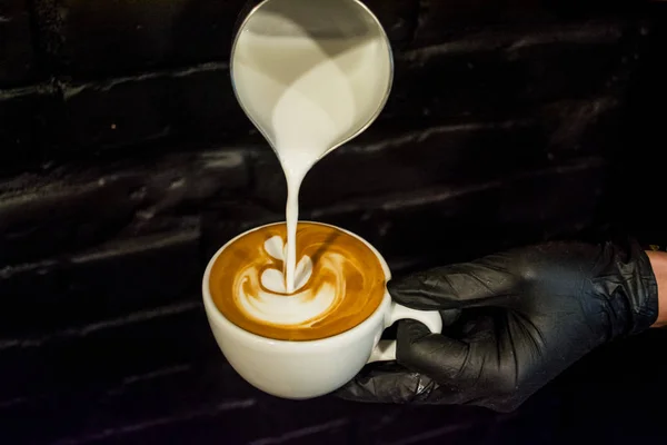 Cappuccino-Tasse mit Latte Art vorhanden. Zubereitung von Kaffee mit Milch. Arbeit Barista. frisches Getränk mit Koffein. — Stockfoto