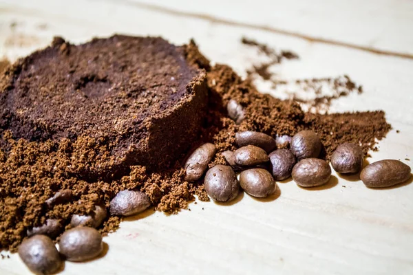 Three stages for preparation of coffee: grain, crushing and the pressed tablet. Wooden surface. Espresso. Work barista.