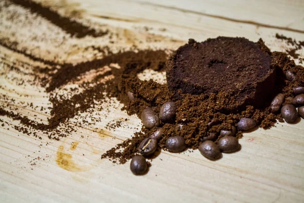 Three stages for preparation of coffee: grain, crushing and the pressed tablet. Wooden surface. Espresso. Work barista.