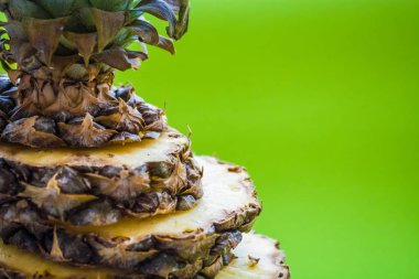 Taze ananas üzerinde yuvarlak parçalar kesin. Tropikal, egzotik meyve yeşil bir arka plan üzerinde. Yaz. Parlak renkler.