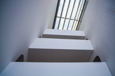 Modern binanın içinde. Eğimli ve yarım daire biçimli duvarlar, büyük pencereler ve balkon, aydınlatma ile. Mimarisi. Geometri.