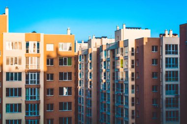 Yeni bir bina modern evlerin. Bina bir kontrast gölge. Güneşli bir gün, mavi gökyüzü. Yard. Sarı duvarlar.