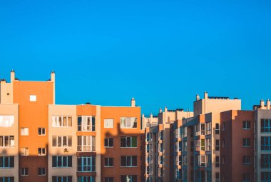 Yeni bir bina modern evlerin. Bina bir kontrast gölge. Güneşli bir gün, mavi gökyüzü. Yard. Sarı duvarlar.
