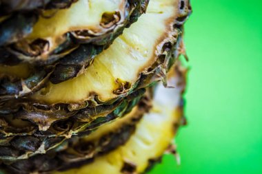 Tropikal narenciye meyve ananas yüzük yeşil bir arka plan üzerinde kesti. Sağlıklı gıda. Egzotik yaz