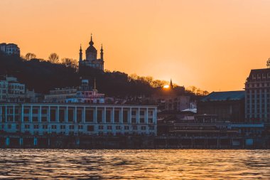 Turuncu günbatımı Nehri yakınında. Ilık bahar günü. Güzel bir akşam şehir manzarası.