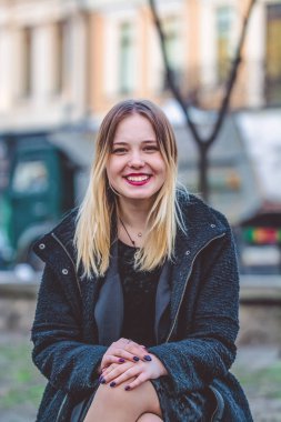 Bahar kadar basit. Genç kız güneşli bir günde bir bankta oturur.