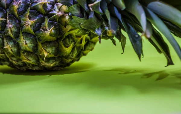 Plakjes van de verse en gesneden ananas op monofische en helder groene achtergrond. Tropisch, citrusvruchten. Exotische. — Stockfoto