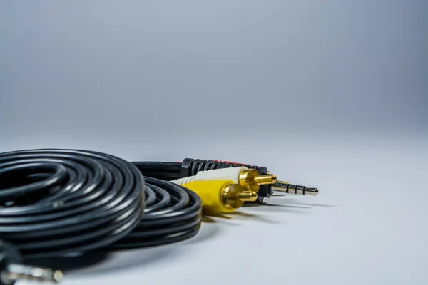 Auf weißem Hintergrund Haken schwarzer Kabel mit bunten Steckern Tulpe. Technologien. ein Multimediadraht für den Fernseher. — Stockfoto