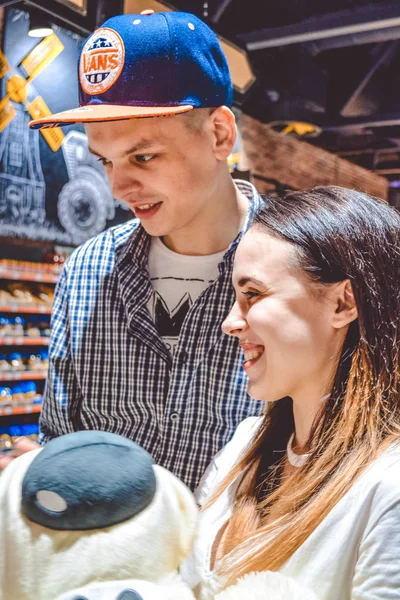 Kiev, Ucrania. 03.03.2019. La pareja joven y cariñosa hace el tonto con diferentes objetos en la tienda. Emociones positivas y diversión. Compras . —  Fotos de Stock