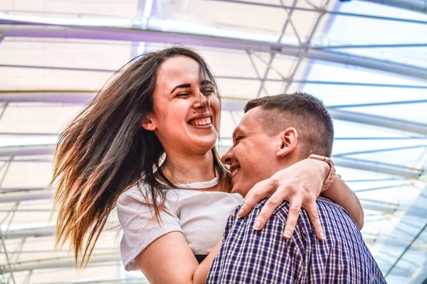 La giovane coppia amorevole per divertirsi nel centro commerciale vicino alla fontana. Emozioni positive. Felicità degli sposi novelli . — Foto Stock