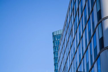 Ofis binaların modern mimarisi. Cam ve metalden bir gökdelen. Mavi gökyüzü pencerelerini yansımalar. İş Merkezi.