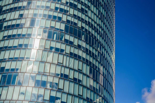 Arquitectura moderna de edificios de oficinas. Un rascacielos de cristal y metal. Reflejos en ventanas de cielo azul. Centro de negocios — Foto de Stock
