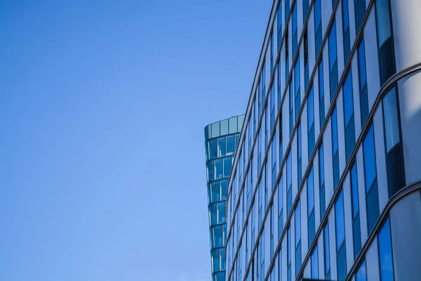 Arquitectura moderna de edificios de oficinas. Un rascacielos de cristal y metal. Reflejos en ventanas de cielo azul. Centro de negocios . — Foto de Stock