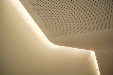 Aydınlatma ve ampuller ile beyaz bir kaplama şeklinde monofonik arka plan veya arka plan. Çizgilerin geometrisi ve minimalizm.