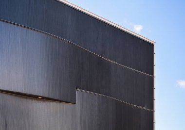 Aydınlatma ile binanın cephe gri kaplama şeklinde arka plan veya doku. Çizgilerin geometrisi ve minimalizm