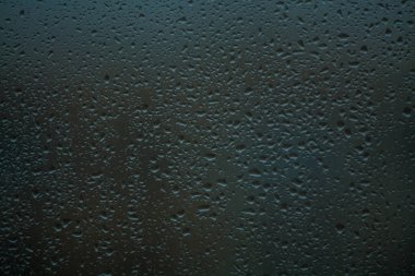 Arka plan veya doku. Pencere camına bir yağmur damlası çok küçük. Baharın yağmurlu günü.