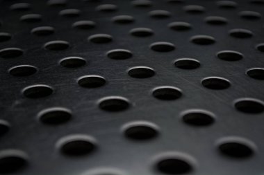 Metal bir plaka delik büyük miktarda gri monofonik arka plan. Yüzey. Doku.