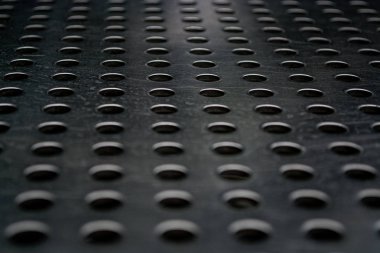 Metal bir plaka delik büyük miktarda gri monofonik arka plan. Yüzey. Doku.