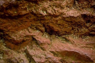 Arka plan veya doku çatlaklar ve bir emprenye bir yosun ile kırık-away partiler ile kırmızı bir taştan. Doğal malzeme.