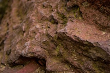 Arka plan veya doku çatlaklar ve bir emprenye bir yosun ile kırık-away partiler ile kırmızı bir taştan. Doğal malzeme.