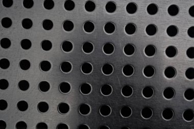 Metal bir plaka delik büyük miktarda gri monofonik arka plan. Yüzey. Doku.