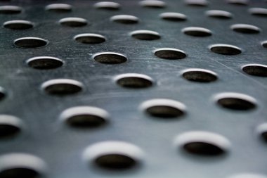 Simetrik ve yuvarlak açıklıklı gri ve monofonik metal bir yüzeyden gelen arkaplan veya doku.