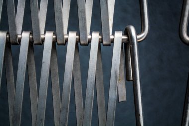 Arka plan veya doku gri bir duvar da metal kendi aralarında iç içe bir tel bir kafes. Kancalar ve döngüler. Çizgilerin geometrisi.