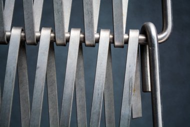 Arka plan veya doku gri bir duvar da metal kendi aralarında iç içe bir tel bir kafes. Kancalar ve döngüler. Çizgilerin geometrisi.