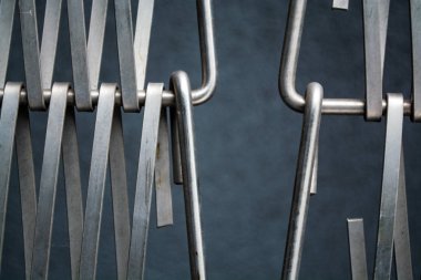 Arka plan veya doku gri bir duvar da metal kendi aralarında iç içe bir tel bir kafes. Kancalar ve döngüler. Çizgilerin geometrisi.