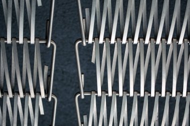Arka plan veya doku gri bir duvar da metal kendi aralarında iç içe bir tel bir kafes. Kancalar ve döngüler. Çizgilerin geometrisi.