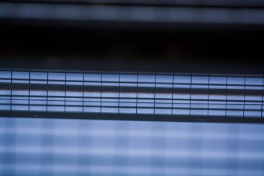 Arka plan veya doku bina kafesler bir crossbeam mavi gökyüzünde. Balkonların görünümü aşağıdan. Kafes, ızgara, tel.