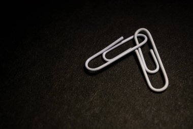 Plastik çok renkli ofis ataş bir dizi siyah monofonik arka plan üzerine dağınık. 