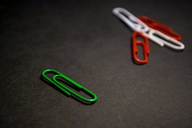 Plastik çok renkli ofis ataş bir dizi siyah monofonik arka plan üzerine dağınık. 