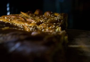 Lezzetli ev yapımı hamur işleri. Tuzlu susamlı turta. Siyah arka plan.